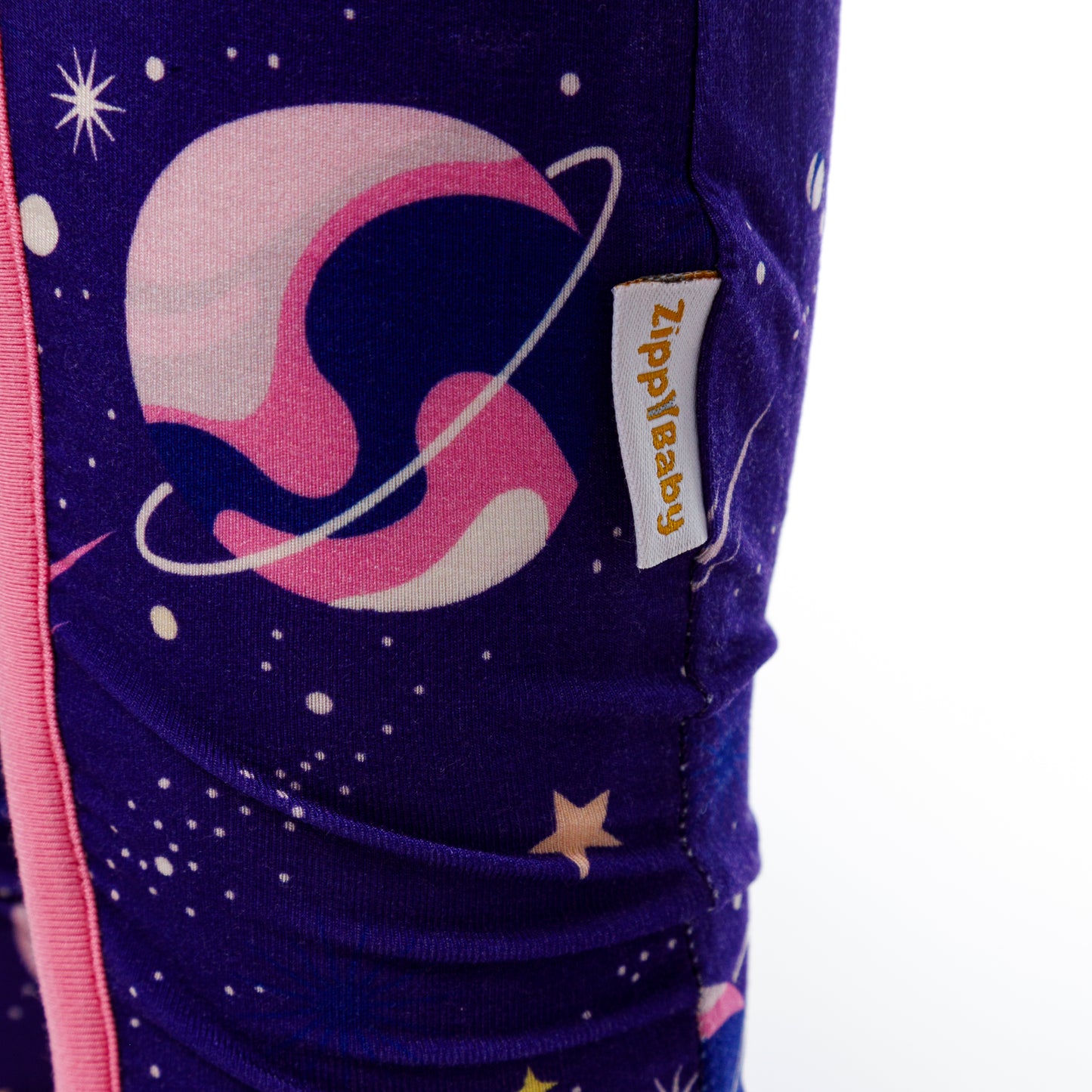 Vedere de aproape a etichetei pe body-ul pentru bebeluși cu imprimeu spațial.