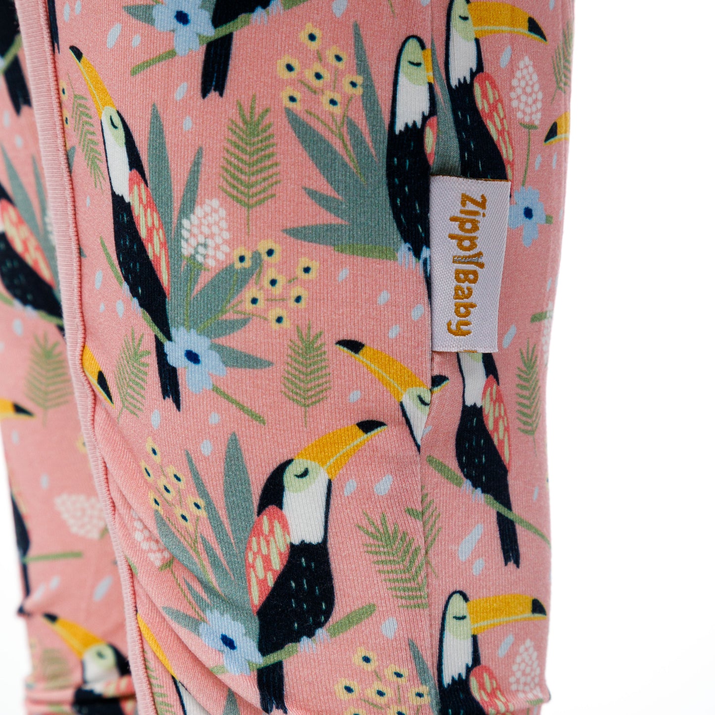  Imprimeu detaliat cu tucani și elemente tropicale pe body-ul pentru bebeluși de culoare roz.